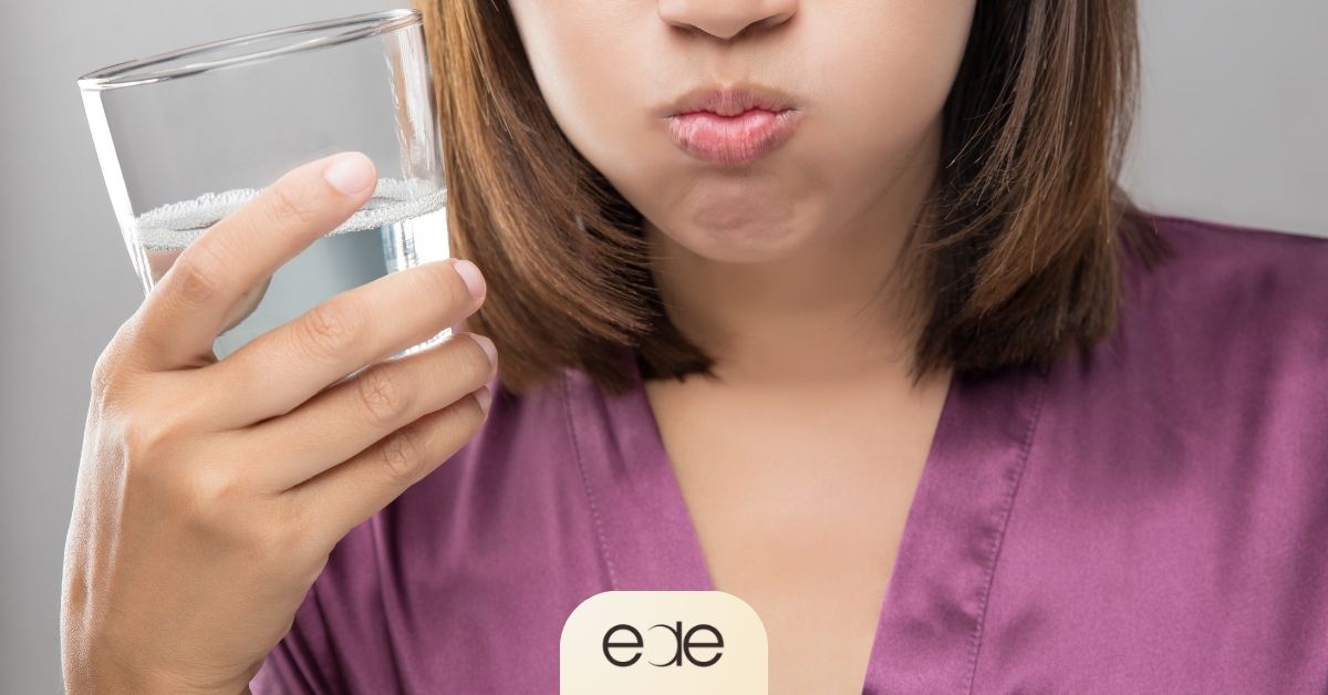 Patient gently rinsing with saltwater to support dry socket prevention after tooth extraction.
