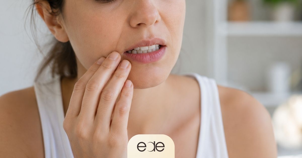 Woman touching her jaw and cheek while experiencing oral discomfort, illustrating how chronic stress and elevated cortisol levels can affect oral health and mouth chemistry
