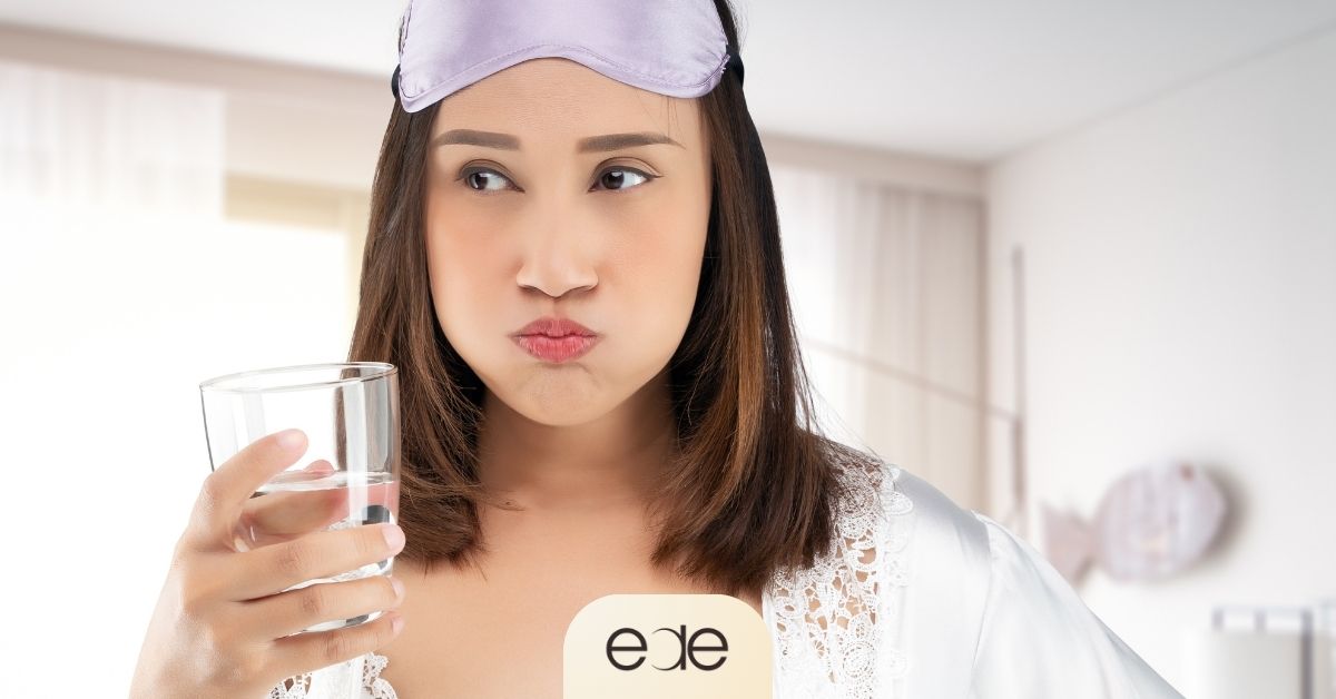 Woman using a glass of water as part of nighttime toothache relief.