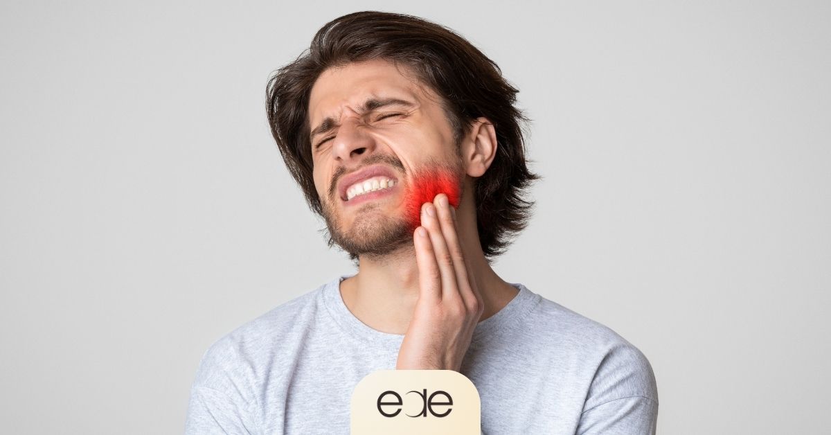 Man holding his swollen cheek in pain from a possible tooth infection.