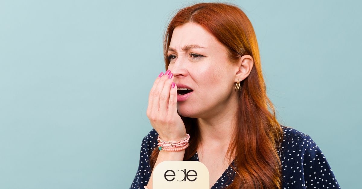 Woman reacting to bad breath, highlighting possible underlying oral health concerns