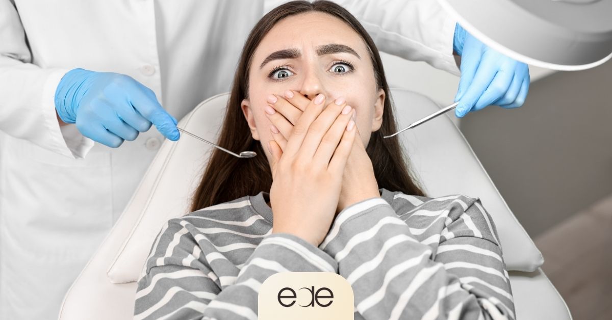 Anxious patient covering her mouth during a dental examination.