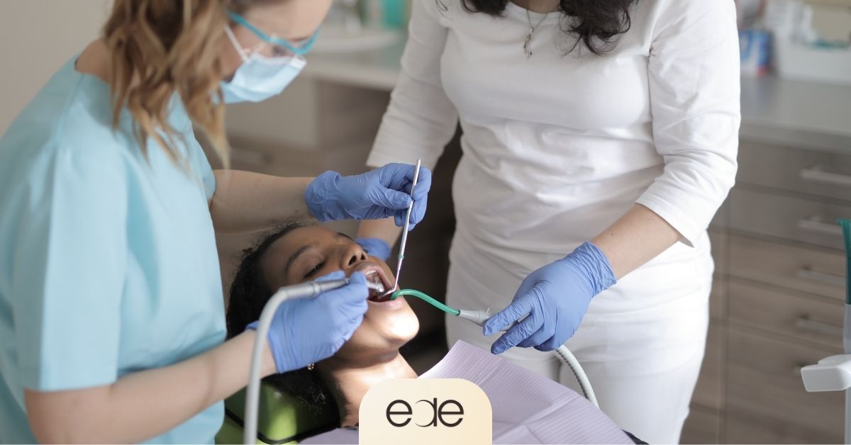 Dental team performing root canal treatment on a patient during a dental appointment.