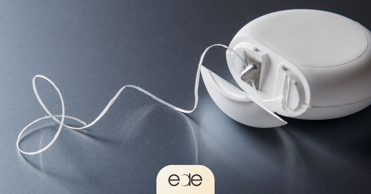 Dental floss extending from a floss container, illustrating the importance of cleaning between teeth to help prevent cavities